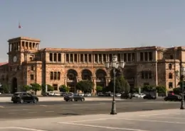 cars parked in front of brown building